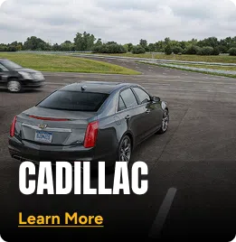 Cadillac parked in a parking lot next to a grass field. Click to learn more