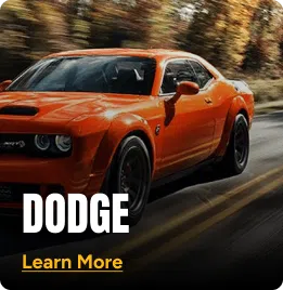 Orange Dodge driving on a narrow road. Click to learn more.