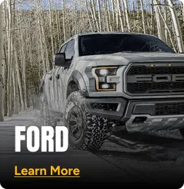 Grey Ford truck driving through the snow. Click to learn more