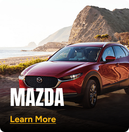 Red Mazda parked alongside a coastline roadway. Click to learn more.